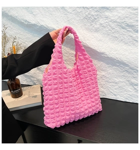 Macro view of pink bubble puff texture and quilted pleated fabric on this cloud tote bag