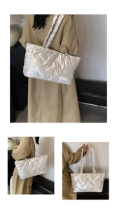 Detailed view of silver quilted tote bag featuring metallic finish and ruched handle