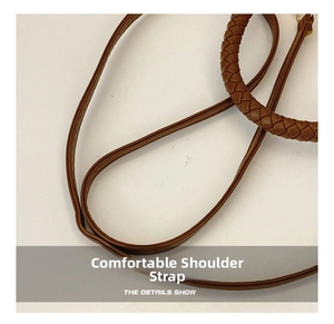 Détails de la bandoulière en cuir marron et de la poignée tressée du sac à main