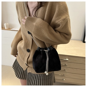 Détail du sac seau en velours noir avec cordon perlé élégant et bandoulière en chaîne
