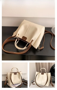 Detail of beige bucket bag showing the contrast brown strap and gold hardware attachments