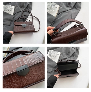 Dettaglio della trama in pelle coccodrillo marrone e chiusura in metallo nero opaco borsa