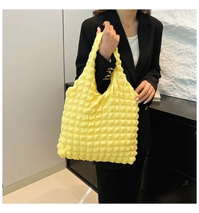 Detailed macro view of bright yellow puff tote bag with popcorn texture fabric
