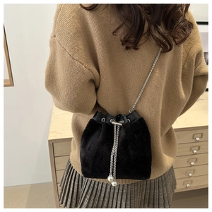 Detail of black faux fur bucket bag with silver chain strap and pearl drawstring accents