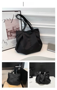 Detail view of large black nylon tote bag with fashion tag and wide shoulder straps