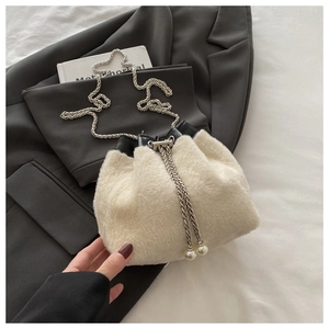Détail du sac seau en peluche blanc cassé avec chaînettes et breloques en perles