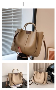 Detail view of khaki faux leather tote bag with cylindrical handles and interior capacity