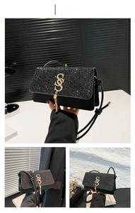Close-up of black sequined crossbody bag with gold tassel logo and leather strap