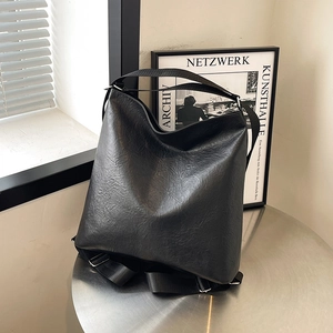 Grand sac cabas noir en cuir plissé avec large bandoulière dans un intérieur moderne