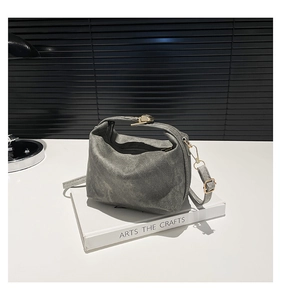 Chic dark gray vintage canvas handbag with metal zipper on a stack of books