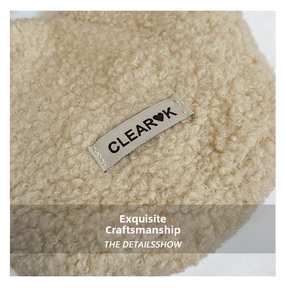 Detailed close-up of warm beige plush fleece fabric texture with stitched brand label