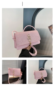 Detail of pink sequin texture with gold S-logo and fringe tassel on stylish shoulder bag