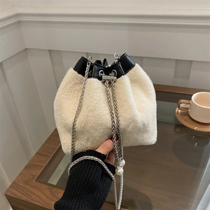 Chic beige faux fur bucket bag with black leather trim and pearl chain strap