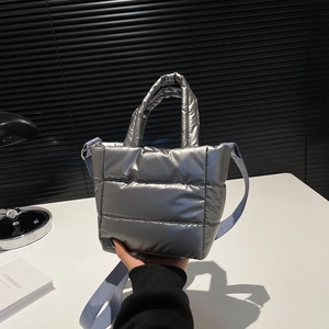 Minimalist silver quilted puffer handbag with adjustable light blue strap for women