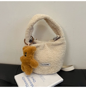 Detail of plush fleece bucket bag featuring CLEAR K patch and brown bear charm