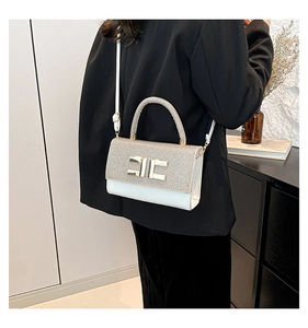 Détail du sac à main en cuir blanc avec rabat pailleté et boucle en métal doré