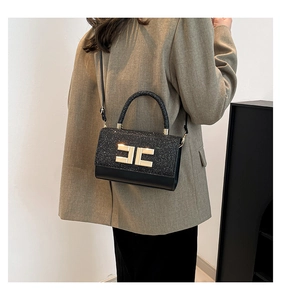 Detail of elegant black sequin and leather crossbody bag with a golden metal buckle closure