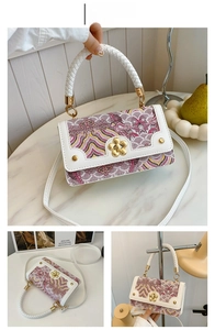 Détail du sac brodé blanc et rose avec fermoir fleur dorée et poignée tressée élégante