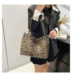 Detail of leopard print tote bag with black double handles and metal hardware buckle