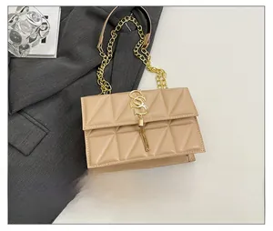 Quilted beige shoulder bag with gold S-buckle tassel and smartphone size comparison
