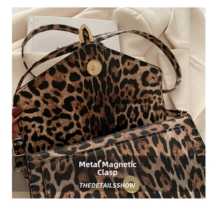 Detailed close-up of leopard print handbag with retro gold magnetic hardware clasp closure