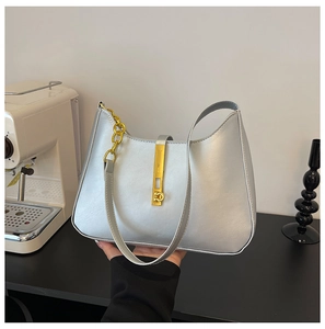 Close-up of silver PU leather handbag with gold metal clasp and chain detail