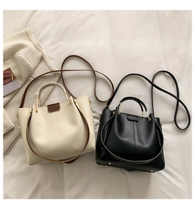 Macro shot of minimalist bucket bags with gold hardware and wear-resistant bottom studs