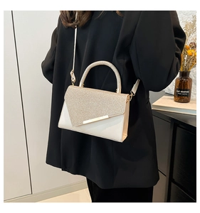 Detail view of stylish cream handbag with glitter flap and metallic handle for women