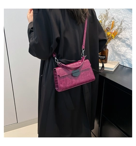 Dettaglio borsa quadrata magenta effetto coccodrillo con fibbia in metallo scuro