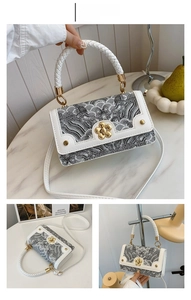 Détail du sac bandoulière vintage avec broderie de vagues et poignée tressée en blanc et gris