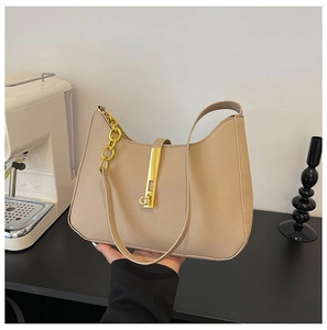 Detail view of beige leather shoulder bag showing gold metal bar buckle and chunky chain