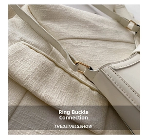 Detail of hardware metal ring link and stitching on cream retro square shoulder bag