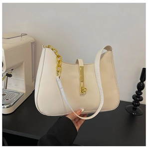 Detailed shot of cream PU leather shoulder bag featuring a gold lock and metal chain strap