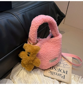 Pink teddy fleece bucket bag with detachable bear charm and crossbody strap details