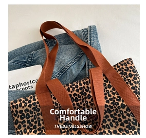 Gros plan d'un sac cabas en toile léopard avec anses marron et veste en jean bleue