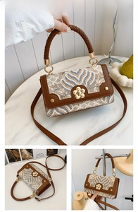 Détail du sac jacquard kaki avec boucle pétale dorée et poignée tressée élégante