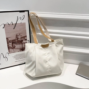 Minimalist white tote bag with brown leather handles and fashion logo for daily work