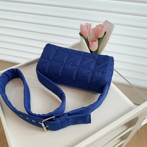 Detail of navy quilted tote with wide strap and silver metal buckle adjustment