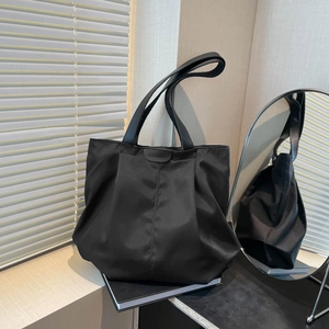 Black large capacity minimalist tote bag with fashion lettering and natural window lighting
