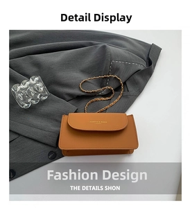 Détail du sac carré en cuir grainé beige avec bandoulière chaîne dorée sur blazer gris