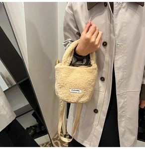 Detail of beige faux fur handbag with curly shearling texture and woven brand label