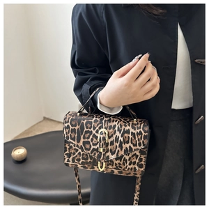 Detail of leopard print handbag showing V-shaped flap and gold U-shaped metal buckle