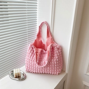 Detail of pink popcorn textured tote bag with soft elastic pleated fabric surface