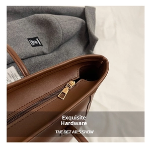 Close-up of golden metal zipper and fine leather texture on brown tote handbag