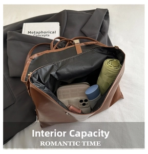 Top view of large brown leather tote interior showing daily items and umbrella