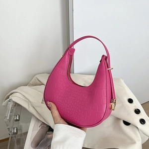 Detail of rose red crescent handbag with crocodile embossing and gold padlock charm