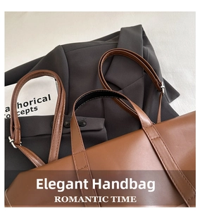 Detail view of brown matte leather handbag with silver adjustable buckle and strap