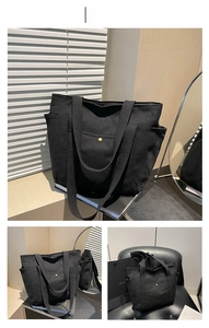 Detail of black canvas tote bag showing side pockets, front snap pocket and wide strap