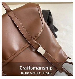 Detail of brown leather bag showing premium stitching, texture and square metal buckle