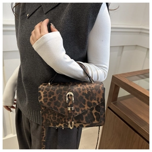 Detail of vintage leopard print crossbody bag featuring golden U-shaped buckle closure